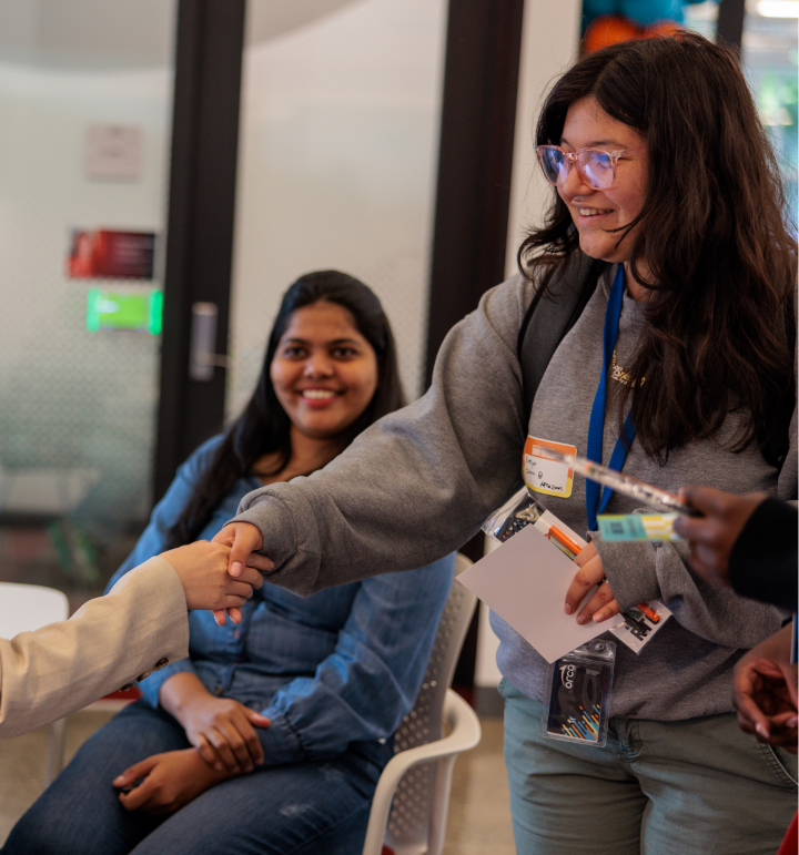 rtc woman shaking hands with a person as another rtc member looks on