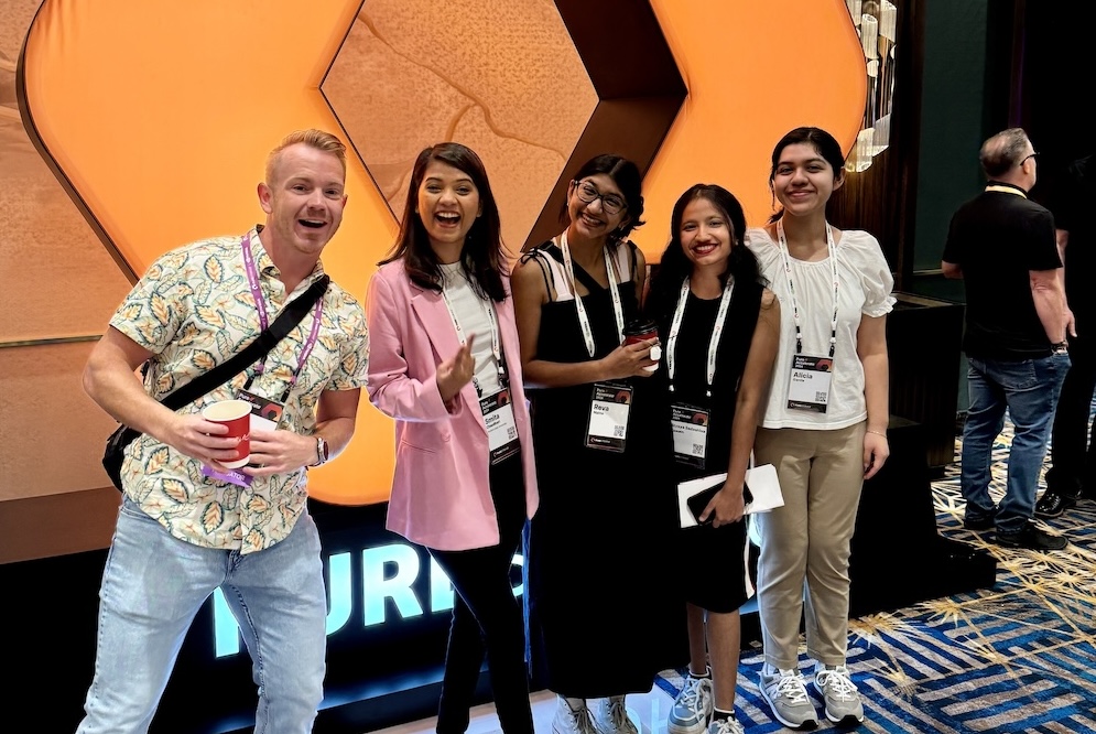 three women and one man smiling excitedly