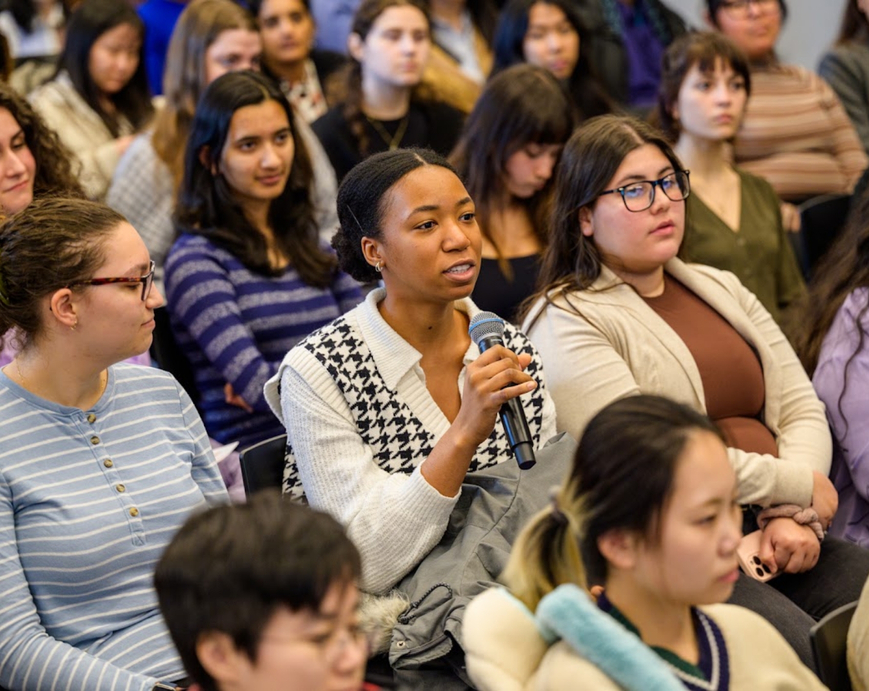 A woman holding a microphone at a Rewriting the Cod eevent