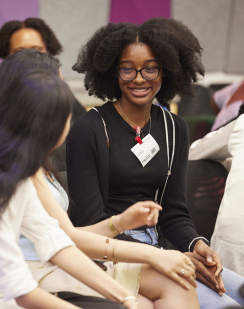 black woman smiling at others at conference