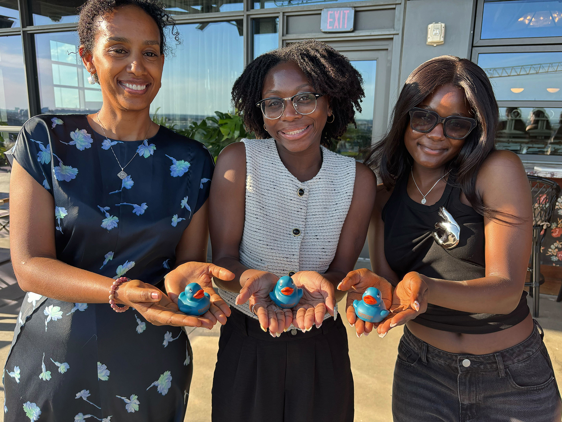 group of women holding plastic rtc ducks