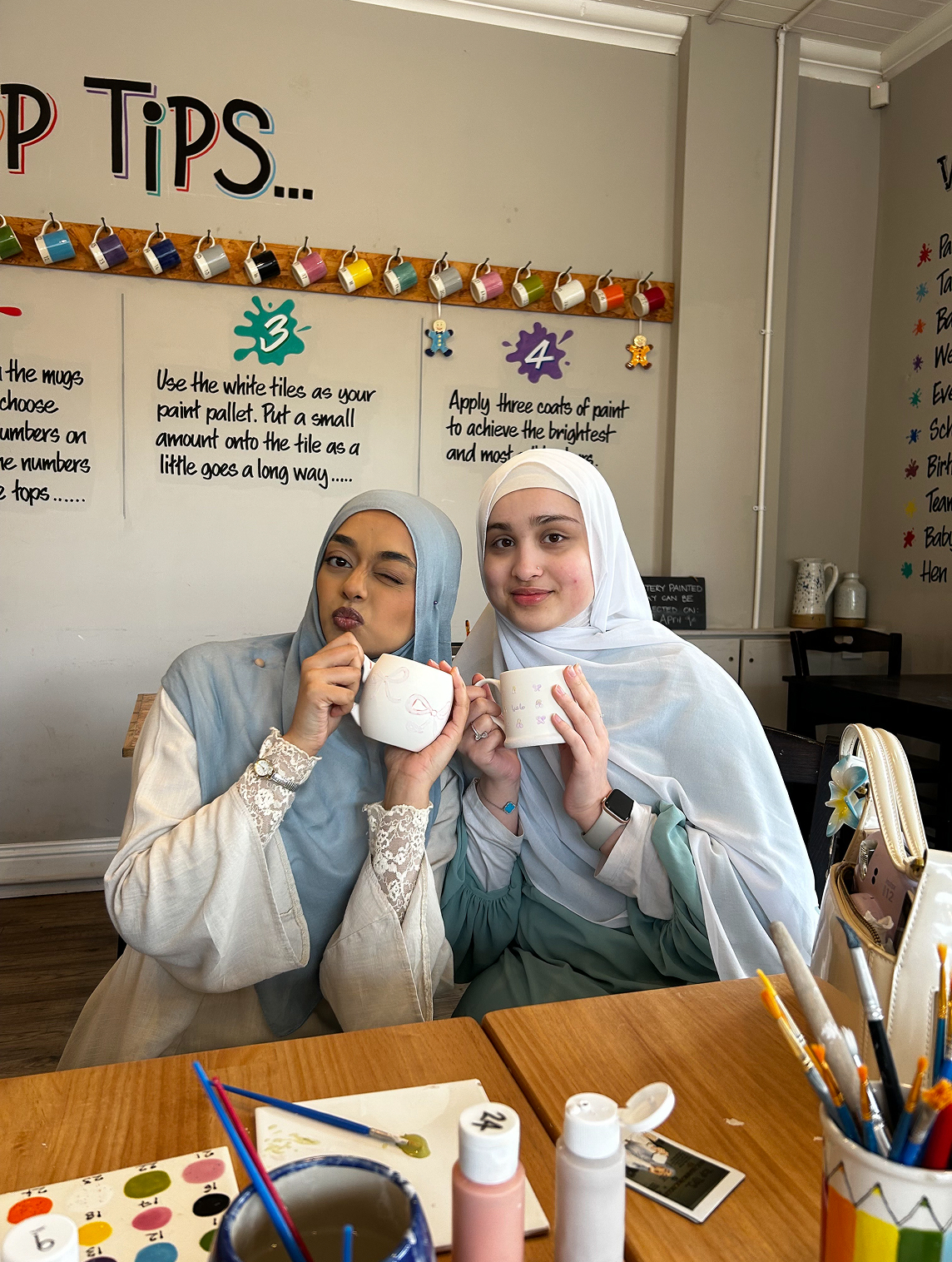 two women smiling and holding mugs