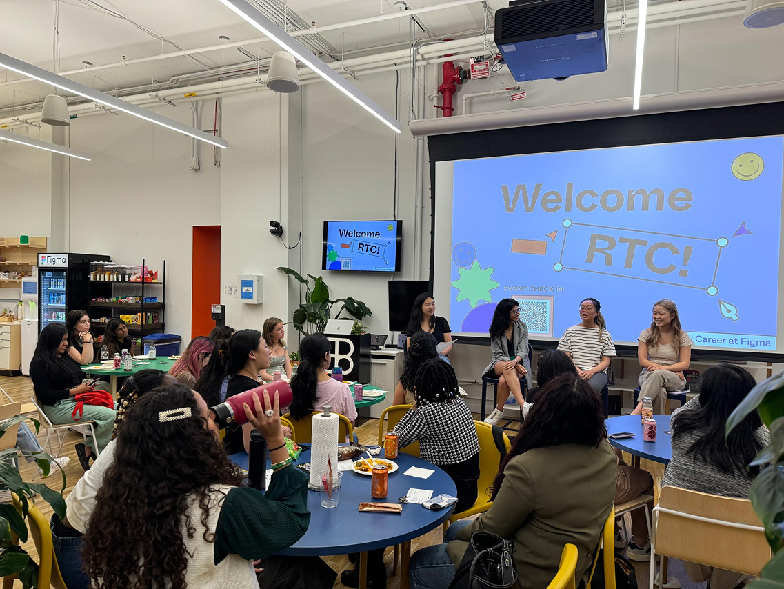 women at a corporate event in front of a welcome RTC presentation
