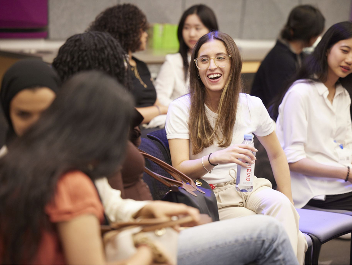woman smiling in glasses with a water bottle