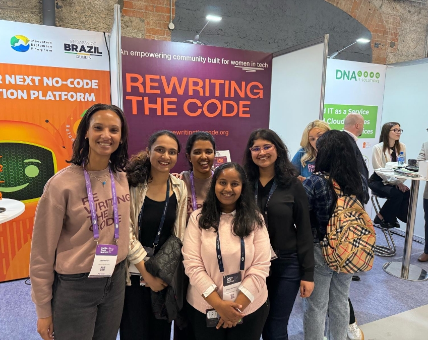 RTC members at a conference smiling in front of an RTC banner