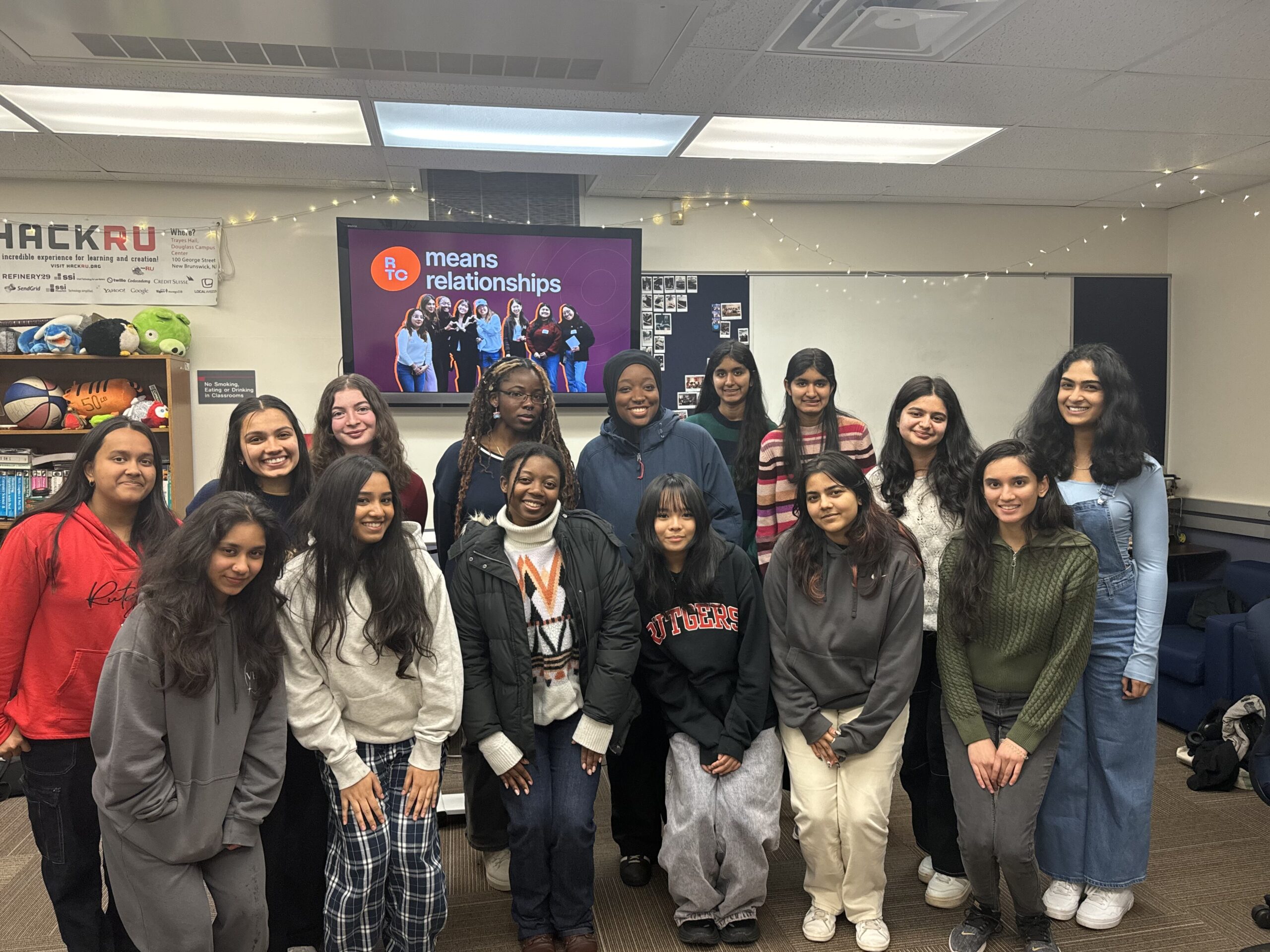 RTC members at Rutger's campus with RTC means relationships on a slide behind them