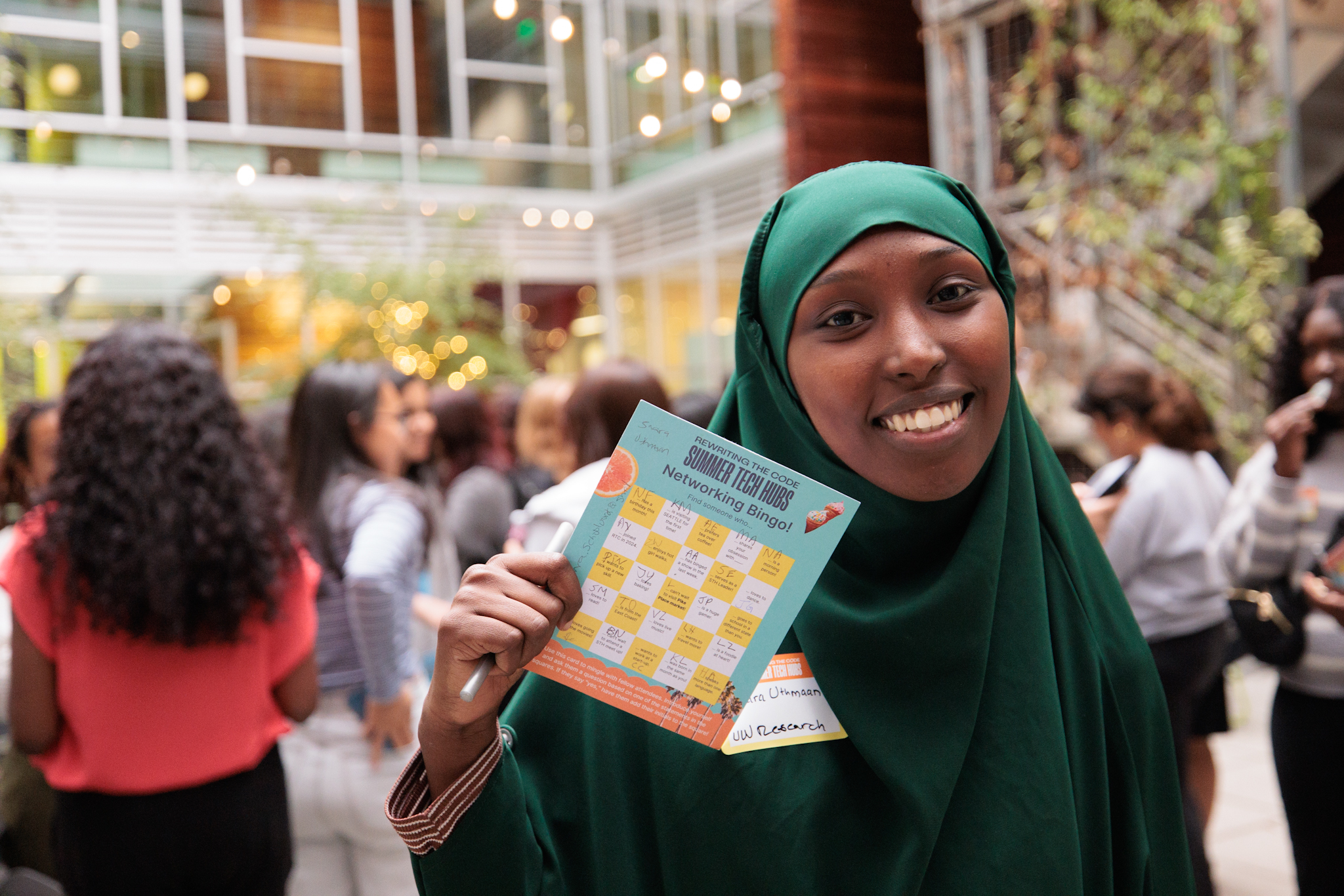 RTC member smiling and holding up a summer tech hubs flyer