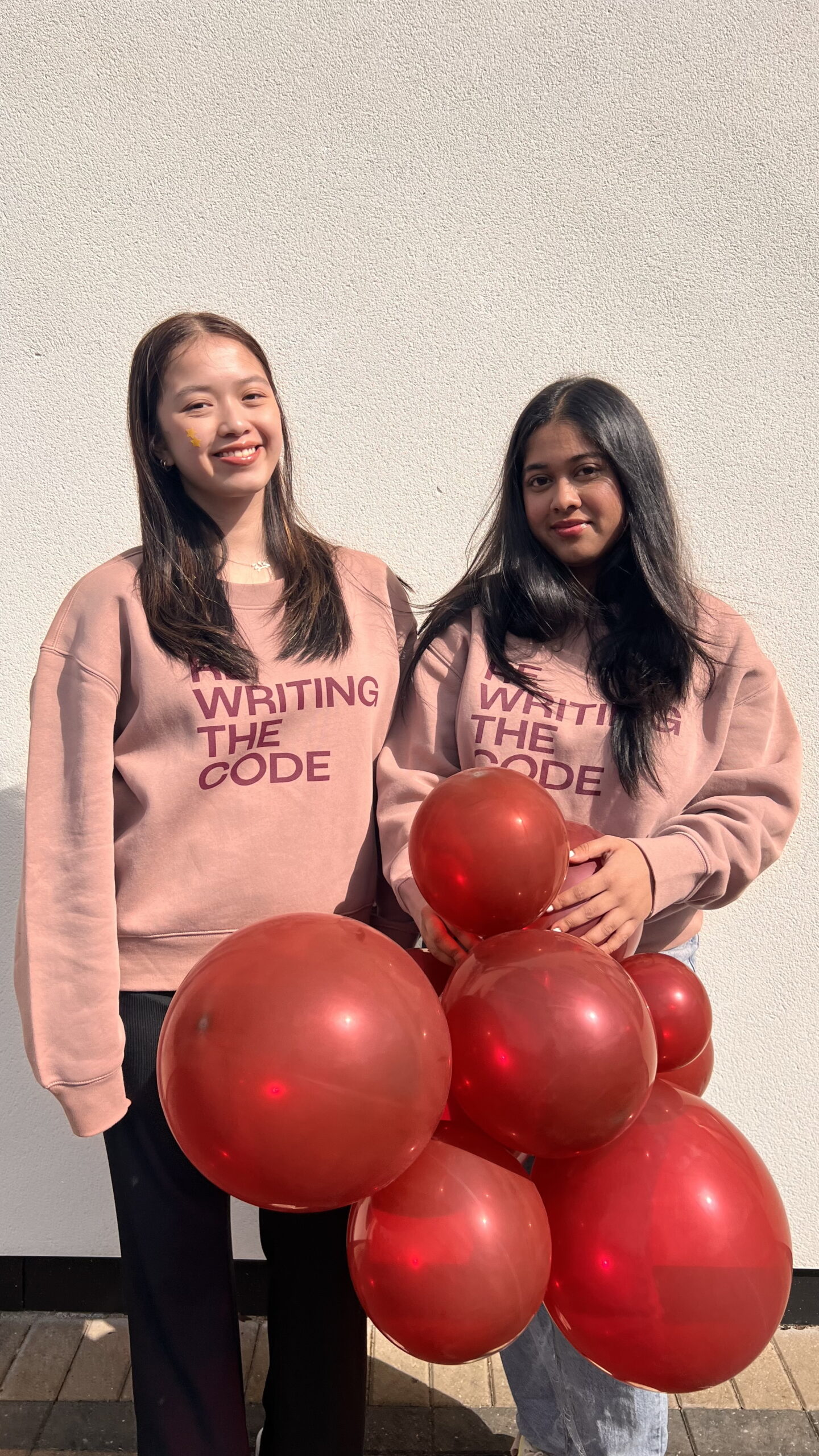 Two RTC members holding balloons and smiling
