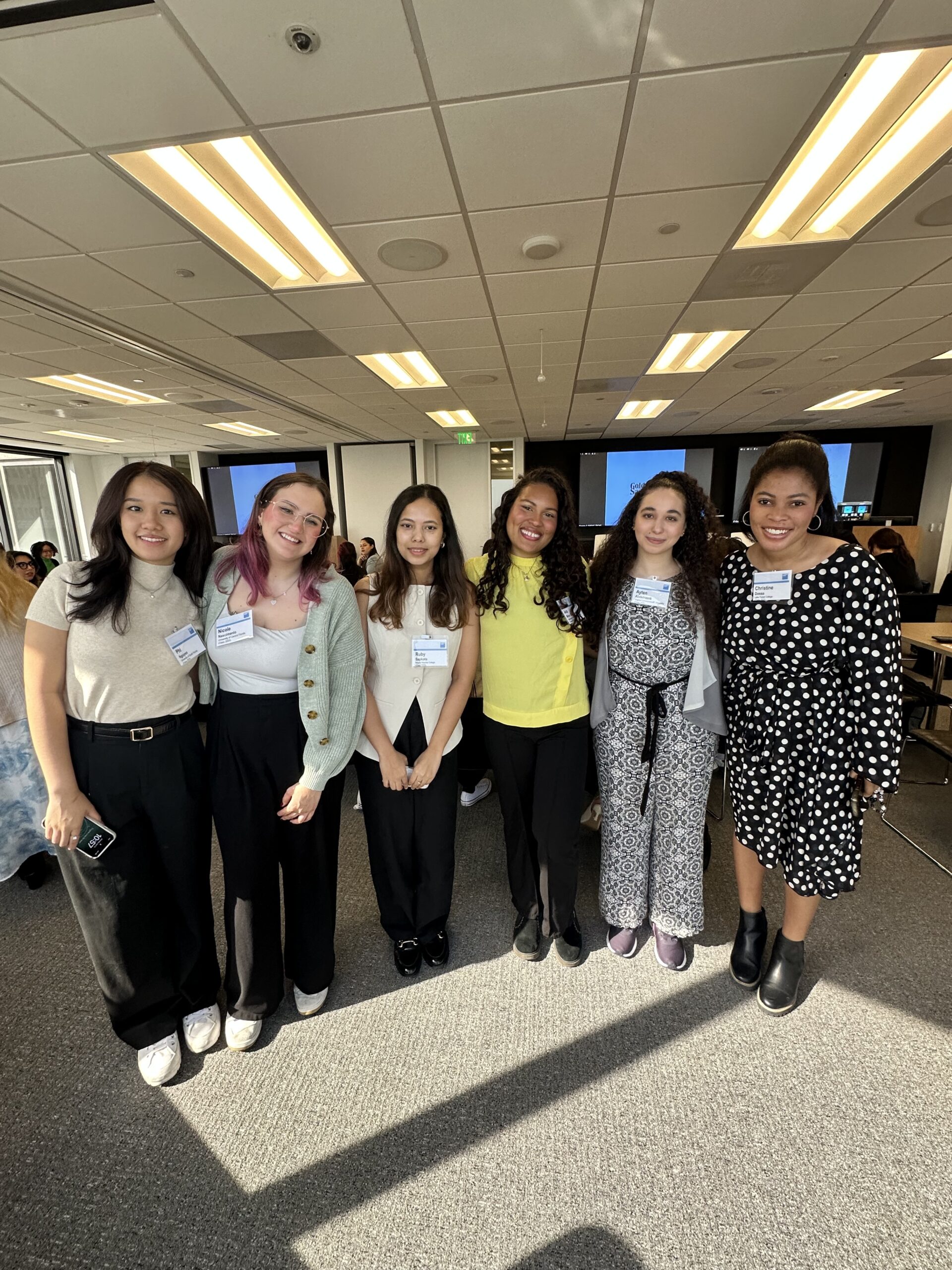 Group of 6 women smiling standing next to each other