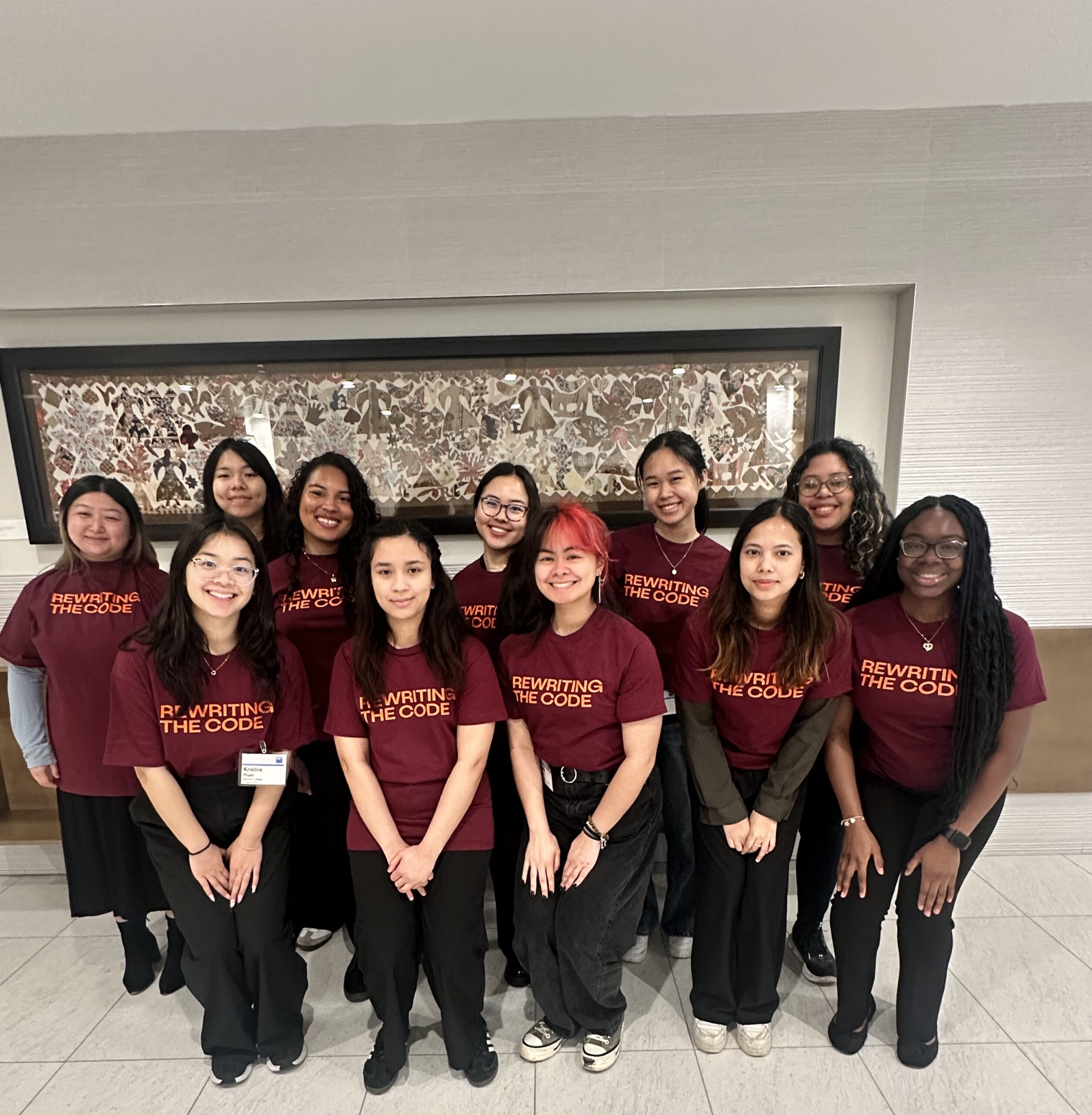 Group of women wearing Rewriting the Code shirts at a company event